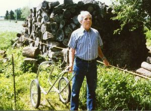 A guy is holding onto a rope guide with one hand while pulling a cart behind him with other hand.